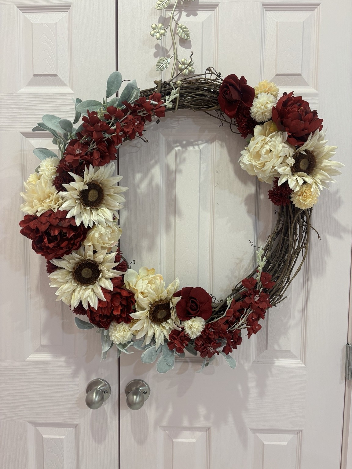 Burgundy and ivory floral wreath on a white door